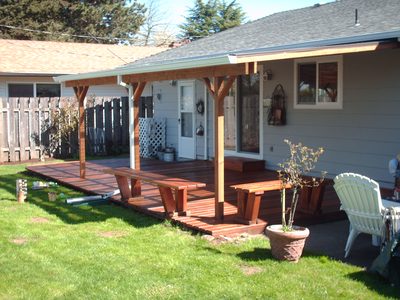 Covered cedar patio and deck addition off the back of a house